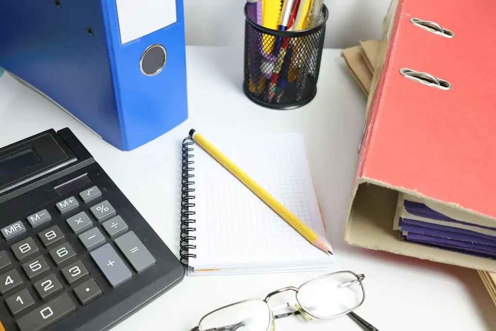 Escritorio con calculadora, carpetas y cuaderno
